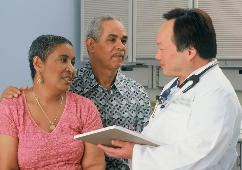 Doctor going over information on a tablet with an older couple