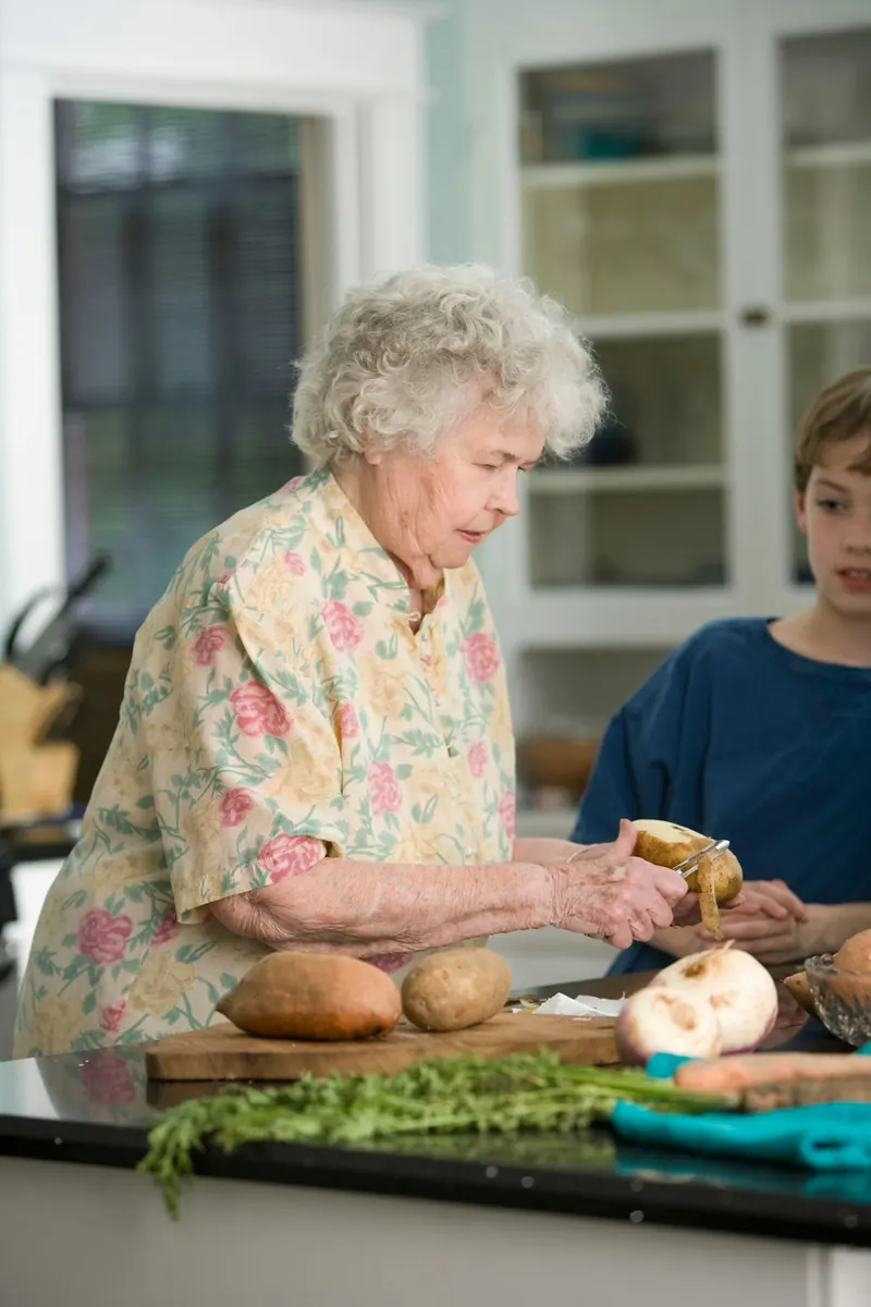 Older woman preparing vegetables in her kitchen