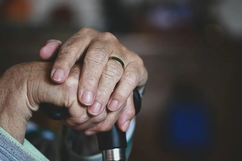 Hands resting on a cane