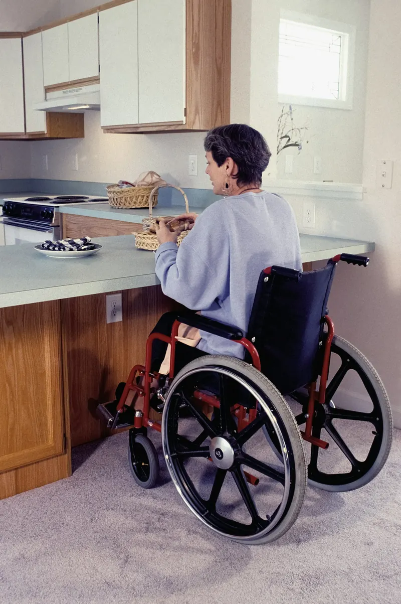 Woman in a wheelchair working at a kitchen counter