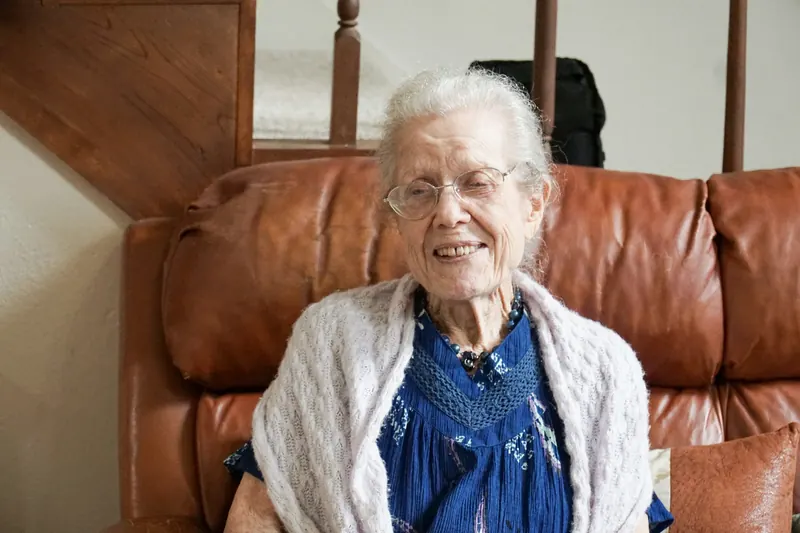 Older woman smiling in a leather armchair